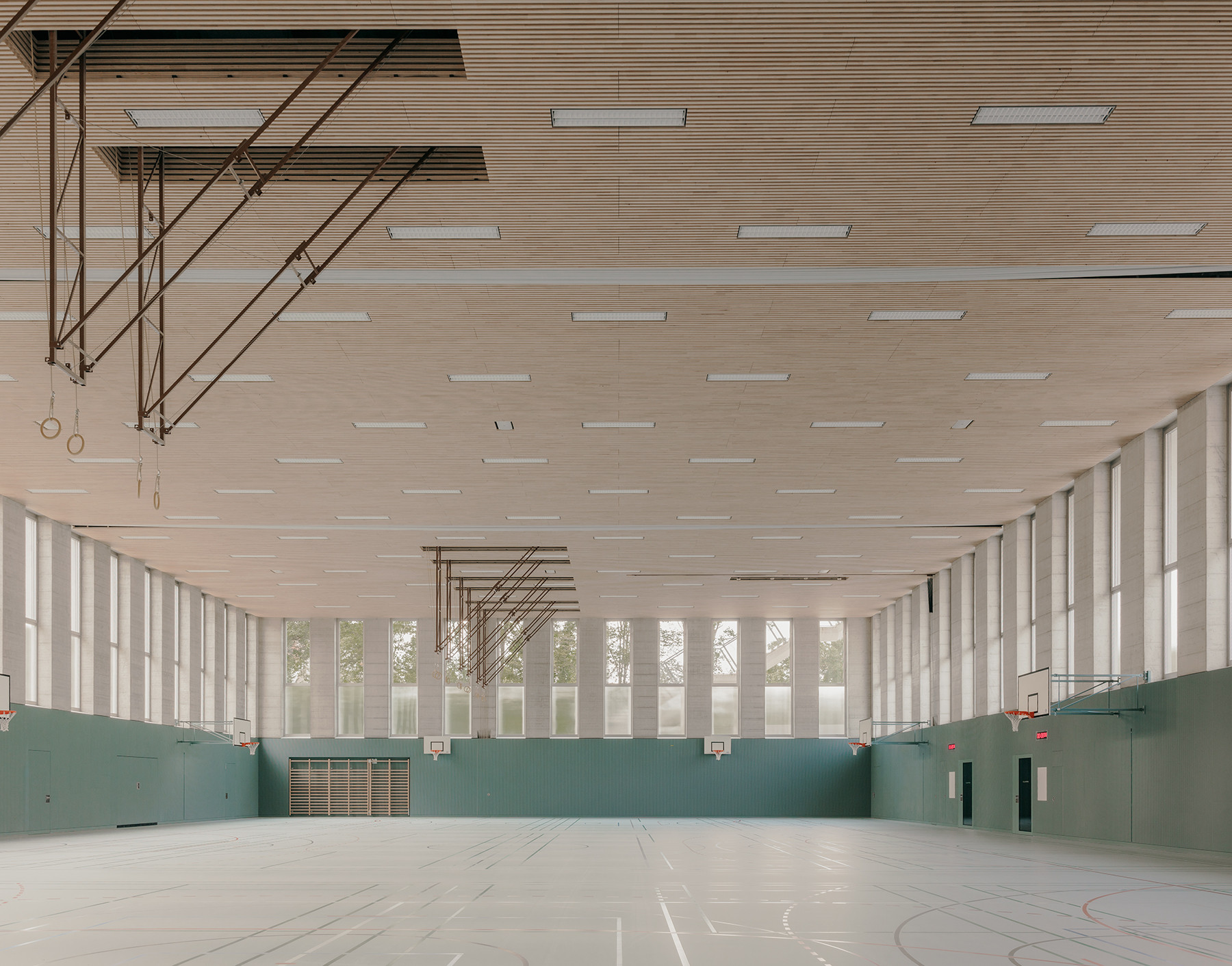 Innenaufnahme der Turnhalle im Schulhaus Zirkusplatz Sursee mit Sicht auf die Holzdecke und Sportausstattung.